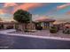 Single-story home with desert landscaping and beautiful sunset in background at 40822 N Harbour Town Way, Anthem, AZ 85086