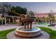 Ornate fountain in a lush backyard landscape with string lights at 4142 E Ravenswood Dr, Gilbert, AZ 85298