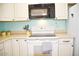 Modern electric cooktop and microwave in a well-lit kitchen at 4201 N 20Th St # 205, Phoenix, AZ 85016