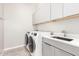 Modern laundry room with washer, dryer, and cabinets at 4415 N Sidney St, Buckeye, AZ 85396