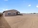 View of the home's exterior from the backyard showing the block wall and dirt in the yard at 4727 N 177Th Dr, Goodyear, AZ 85395