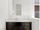 Bathroom vanity featuring sleek dark wood cabinets, a white countertop, and modern hardware at 4727 N 177Th Dr, Goodyear, AZ 85395