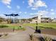 Community playground area with covered play structures and lush green lawns under a partly cloudy sky at 4727 N 177Th Dr, Goodyear, AZ 85395