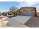 House exterior with gray garage doors and desert landscaping at 6843 W Samantha Way, Laveen, AZ 85339