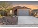 Single-story home with gray garage door and desert landscaping at 6843 W Samantha Way, Laveen, AZ 85339