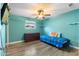 Light teal bedroom with wood-look floors and a twin bed at 7214 N 35Th Ave, Phoenix, AZ 85051