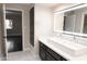 Modern bathroom with double vanity, mirror and adjacent bedroom view at 9025 N 86Th Pl, Scottsdale, AZ 85258