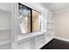 Built-in white bookshelves with window and dark hardwood floors at 9025 N 86Th Pl, Scottsdale, AZ 85258