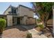 Front view of a light beige, two-story townhome with a walkway and landscaping at 9054 N 51St Ln, Glendale, AZ 85302