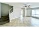 Bright living room with tile floors, staircase, and ceiling fan at 9054 N 51St Ln, Glendale, AZ 85302