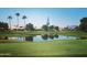 Scenic golf course view with a pond and palm trees at 9637 E Sundune Dr, Sun Lakes, AZ 85248