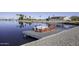 Private boat dock with pontoon boat on a calm lake at 10178 W San Lazaro Dr, Arizona City, AZ 85123