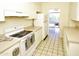 Kitchen with white appliances and cabinets, beige countertops, and tiled floors at 102 W Maryland Ave # B2, Phoenix, AZ 85013