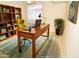 Virtually staged home office with a large desk, bookcase, and comfortable chair at 102 W Maryland Ave # B2, Phoenix, AZ 85013