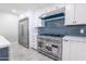 Modern kitchen with stainless steel range, blue tile backsplash, and white cabinets at 11252 N 37Th St, Phoenix, AZ 85028