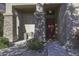 House entrance with stone columns, red door and landscaping at 1240 W Falls Canyon Dr, Casa Grande, AZ 85122