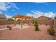 A beautiful backyard with a custom pergola and desert landscaping featuring a stone fire pit for outdoor entertaining at 12474 W Redfield Rd, El Mirage, AZ 85335