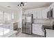 Kitchen featuring stainless steel appliances, white cabinetry, quartz countertops, and a bright window at 12474 W Redfield Rd, El Mirage, AZ 85335