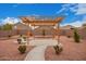 Pergola offering shade over a backyard patio space with desert landscaping at 12474 W Redfield Rd, El Mirage, AZ 85335