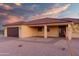 Single-story house with a terracotta roof, desert landscaping, and brick accents, showcasing a brown garage door and light fixtures at 125 Ironwood Pl, Wickenburg, AZ 85390