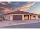 View of single-story home featuring desert landscaping, a terracotta roof, and a brown garage door, with an exterior electrical panel at 125 Ironwood Pl, Wickenburg, AZ 85390