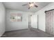 Bedroom with ceiling fan, carpet flooring, and barn door at 12962 W Catalina Dr, Avondale, AZ 85392