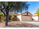 Single-story house with a two-car garage and landscaped front yard at 13353 W Port Royale Ln, Surprise, AZ 85379