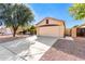 Single-story house with a two-car garage and desert landscaping at 13353 W Port Royale Ln, Surprise, AZ 85379