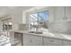 White kitchen cabinets, quartz countertops, and stainless steel appliances at 14202 N Lakeforest Dr, Sun City, AZ 85351