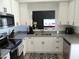 Bright kitchen with white cabinets, gray counters, and view to living room at 1435 S Spartan St, Gilbert, AZ 85233