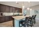 Island kitchen with dark wood cabinets and granite countertops at 16464 W Piccadilly Rd, Goodyear, AZ 85395