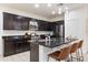 Modern kitchen with dark cabinetry, granite counters, and island at 1705 S 82Nd Pl, Mesa, AZ 85209