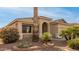 Front view of a tan house with arched entryway and mature landscaping at 18109 W Skyline Dr, Surprise, AZ 85374