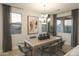 Bright dining room with large windows and a rustic wood table at 19021 W Rose Ln, Waddell, AZ 85355