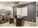 Modern home office with wood desk and shelving at 19021 W Rose Ln, Waddell, AZ 85355