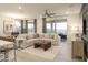 Relaxing living room featuring a sectional sofa, coffee table, and ceiling fan at 19021 W Rose Ln, Waddell, AZ 85355