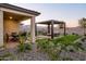 Landscaped backyard with patio, pergola, and seating area at 19027 W Rose Ln, Waddell, AZ 85355