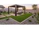 Pergola, seating area, and artificial turf in backyard at 19027 W Rose Ln, Waddell, AZ 85355