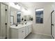 Elegant bathroom with double vanity, large mirror, and a shower at 19027 W Rose Ln, Waddell, AZ 85355