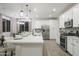 Modern kitchen with white cabinets, large island, and stainless steel appliances at 19027 W Rose Ln, Waddell, AZ 85355