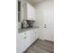 Laundry room with white cabinets, countertop, and wood-look tile floor at 19027 W Rose Ln, Waddell, AZ 85355