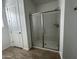 Modern bathroom with a glass-enclosed shower, white door, and neutral flooring at 22859 E Lords Way, Queen Creek, AZ 85142