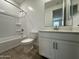 Clean bathroom with a white vanity, framed mirror, toilet, and shower-tub combination with white tile surround at 22859 E Lords Way, Queen Creek, AZ 85142