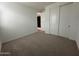 Bedroom features neutral carpet, large closet, freshly painted white walls, and a view into hallway at 22859 E Lords Way, Queen Creek, AZ 85142