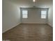 A bright bedroom featuring tile flooring, fresh white walls, and two windows with blinds for natural light at 22859 E Lords Way, Queen Creek, AZ 85142