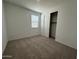 A bright bedroom featuring neutral carpet, fresh white walls, and a window with blinds for natural light and closet at 22859 E Lords Way, Queen Creek, AZ 85142