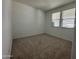 Bright bedroom with neutral carpet, two windows with blinds, and freshly painted white walls at 22859 E Lords Way, Queen Creek, AZ 85142