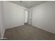 A bright bedroom featuring neutral carpet, fresh white walls, and a doorway at 22859 E Lords Way, Queen Creek, AZ 85142