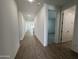 Bright hallway with wood-look tile flooring, leading to bedrooms and living areas at 22859 E Lords Way, Queen Creek, AZ 85142