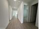 Bright hallway featuring wood-look tile flooring, white walls, and doorways leading to various rooms at 22859 E Lords Way, Queen Creek, AZ 85142